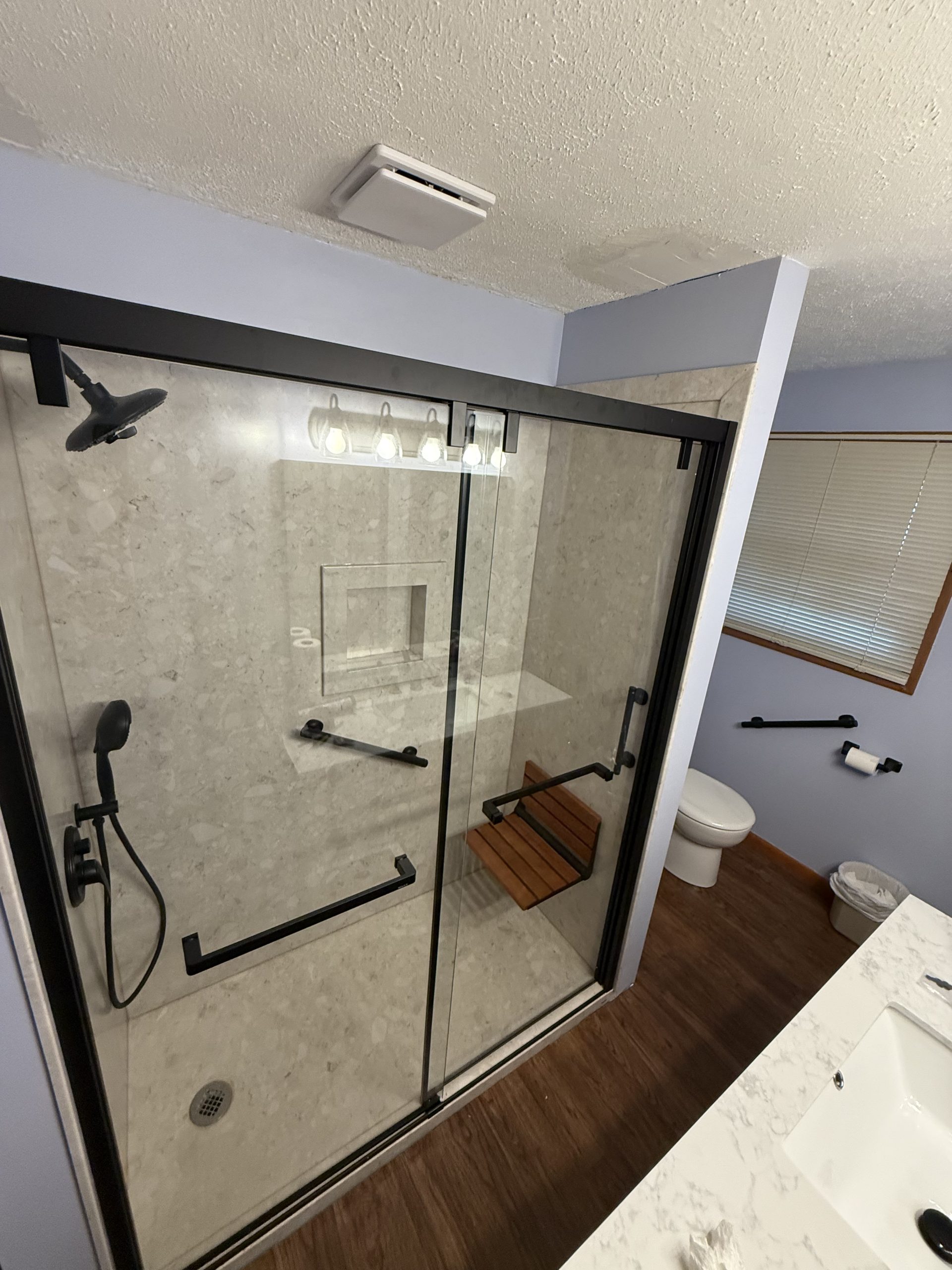 Accessible bathroom remodel with walk-in shower, bench seat, and grab bars in Northeast Ohio