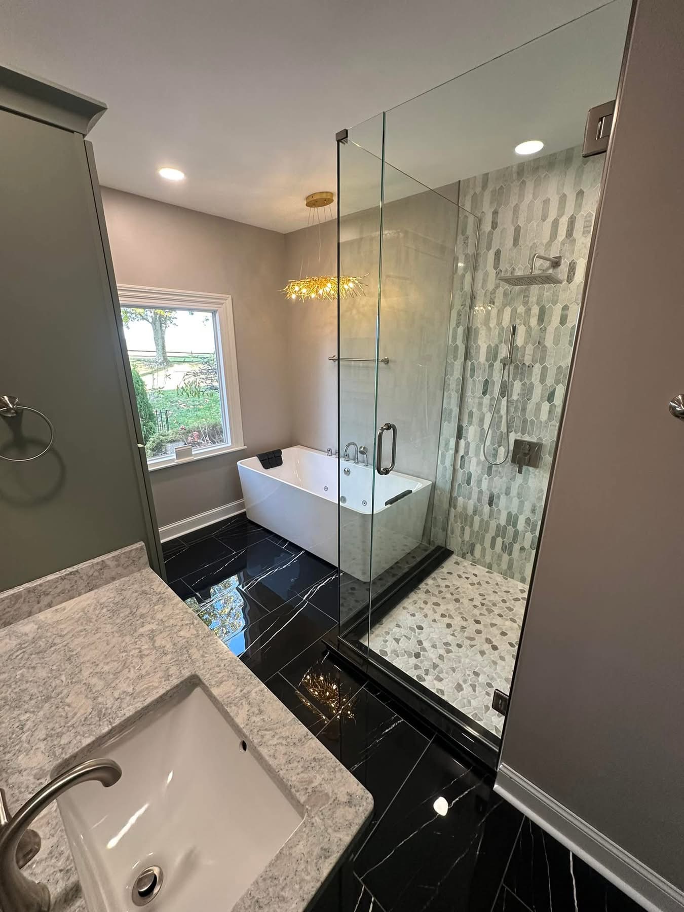 A whole-bath remodel by Stark Elite — freestanding tub, glass shower, and a green vanity, sequenced inside a larger whole-home program.