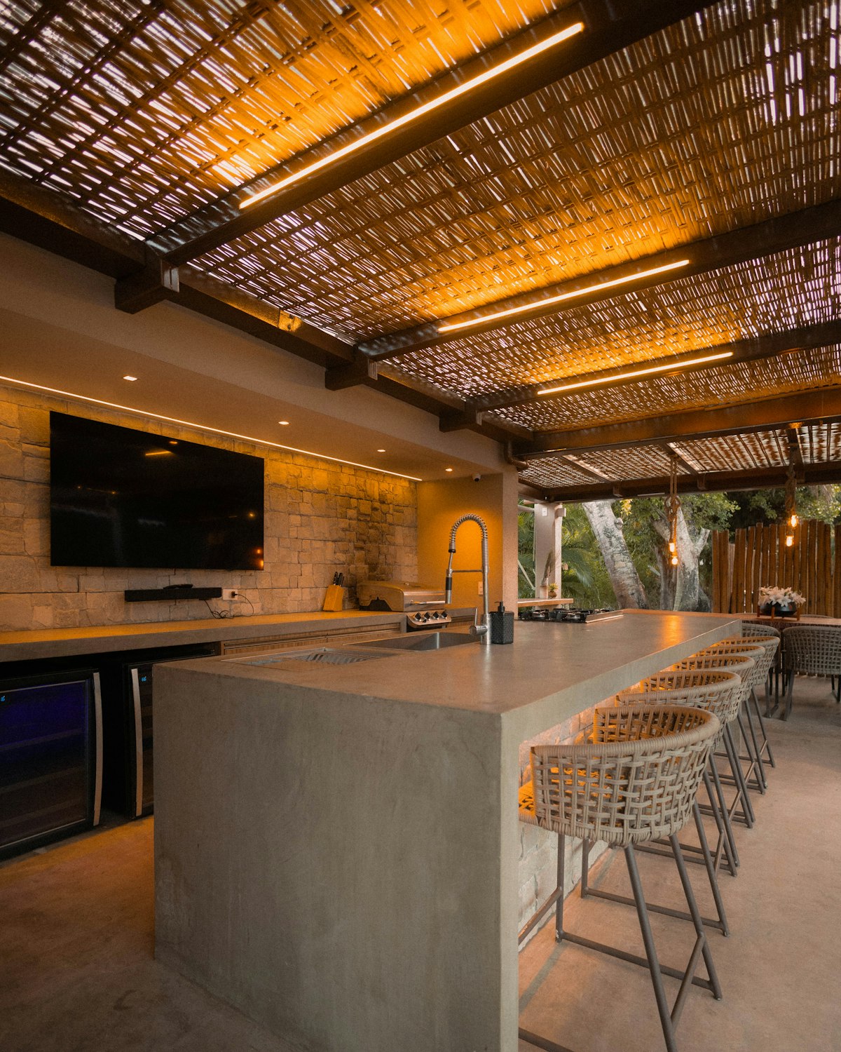 Outdoor living space with concrete bar and woven pergola in Northeast Ohio