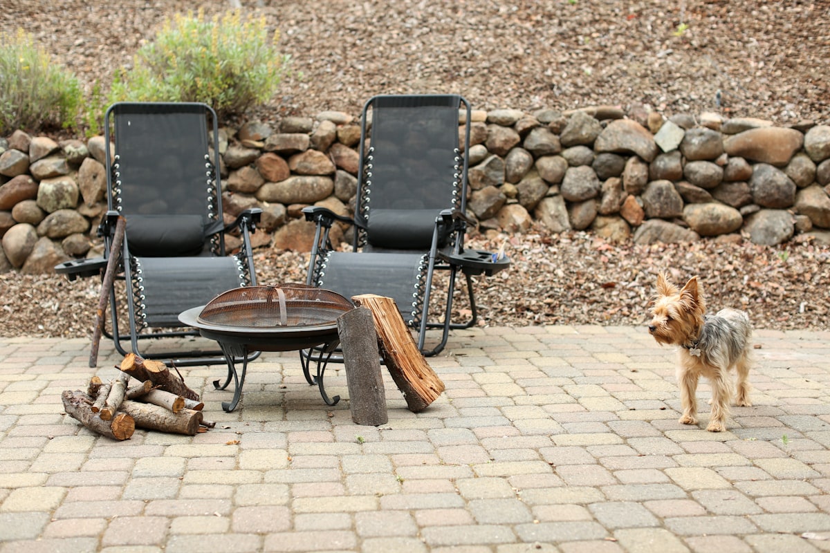 Stone fire pit with seating wall on brick patio in Stark County, Ohio